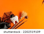 Small photo of dentistry.dental.halloween. holiday concept. holidays. dentist.character for dentist halloween card.dental concept. figurines of teeth in halloween costumes and dental instruments. pumpkins and broom
