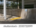 Small photo of Street ramp for people with disabilities in a wheelchair. Entrance to the building with handrails and to help handicapped people. Tactile slab and wheelchair sign