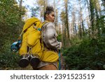 Small photo of A curly-haired forest wanderer, enjoying the serene atmosphere of an autumn forest trail, accompanied by her trusty binoculars.