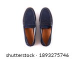 Cropped shot of a pair of dark blue penny loafers. Men's shoes isolated on white background. Suede moccasin without laces. Top view, copy space for text, flat lay.