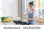 Attractive asian woman cooking...