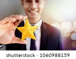 Success in Business or Personal Talent Concept. Happy Businessman in black suit Smiling and Showing a Golden Star in Hand