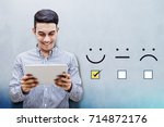 Customer Experience Concept, Happy Businessman holding digital Tablet with a checked box on Excellent Smiley Face Rating for a Satisfaction Survey