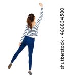 Small photo of back view of writing beautiful woman. Rear view people collection. backside view of person. Isolated over white background. Girl in a striped sweater standing on tiptoes and draws marker.