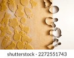 Raw Easter cookies and cookie cutters on baking paper top view. High quality photo