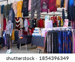 Small photo of Bognor Regis, Sussex / UK - 7 Nov 2020: High street market trader adds a few token toilet rolls and loaves of bread to a clothing stall to circumvent the Covid-19 national lockdown. Shallow focus.