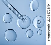 Small photo of Blobs of gel or thick liquid resembling hyaluronic acid or keratin. Dropper with bubbles in scientific background. Bubble textures and a pipette.