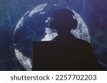 Small photo of Silhouette of a military man in headphones at a laptop against the background of a digital globe of the earth, contour lighting. Concept: collection of confidential information, surveillance.