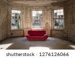 An Old Red Sofa In The Empty...