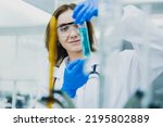female researcher, medical scientist or doctor with test tube of clear liquid in laboratory, chemist developing concept