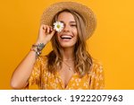 beautiful attractive stylish woman in yellow dress and straw hat holding daisy flower romantic mood posing on yellow background isolated in love summer fashion trend style, natural look