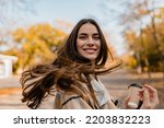 Small photo of candid attractive young smiling woman walking in autumn park with coffee wearing checkered coat, happy mood, fashion style trend, long brown hair
