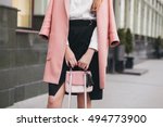young stylish beautiful woman walking in street, wearing pink coat, holding purse, black skirt, fashion outfit, autumn trend,  accessories, hands close-up, details