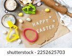 Background for baking or cooking Easter cookies. Ingredients and kitchen utensils for baking on a light stone table. View from above. 