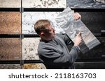 Small photo of a man in the granite tile department shows one piece of granite he has chosen.