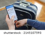 Flight cancelled. Smartphone application announces bad news to tourist. Man holding mobile phone in hotel room. Smart phone with flight cancelled concept on screen. 