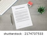 Business document paper of sale agreement. Waiting to sign sales agreements on a desk with a pen, stamp, and plant. Business contract.