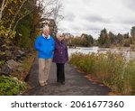 A couple of active over eighty years old spend a fall day in their home town Bracebridge, Ontario. They are helping each other and love to spend time outdoor admiring Autumn leaf colour and scenery