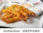 Fried shrimps on sticks in crispy coating with sauce
