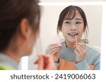Small photo of A woman applying Vaseline on her lips
