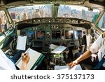 Flight in airplane cabin interior on New York skyline of United States of America.. Pilots arms and blank white papers for copy space