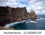 The ocean with high rocky cliffs in Madeira at the Ponta de São Lorenço during a hike on a trail in Madeira with more tourists