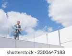 Small photo of Portrait of confident businessman with hands clasped on balcony