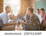 Group watching man and woman talking in group therapy session