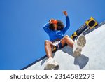 Small photo of Low angle view young woman with boom box using view finder toy, looking up at sunny blue sky