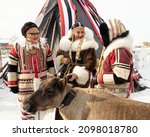 Small photo of Dudinka, Taimyr, Russia, April, 10, 2021: Festival 90th anniversary of Dudinka. Portrait of three women in national costumes of the peoples of the north near the traditional chum with a deer.
