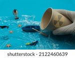 Small photo of White gloved hands hold Paper Cup with nuclear radiation warning symbols and pour water into sea. Nuclear waste water. Pollutant discharge. Ecological damage. Chemical contamination.Environmental