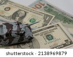 Small photo of Tanks are placed on top of dollar bills. A metaphor for currency warfare, financial crises, trade wars, tariff penalties, international competition, war costs, and military spending.