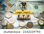 Small photo of exchange-traded fund (ETF) is a type of pooled investment security that operates much like a mutual fund.The word is written on money and gold background