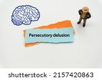 Small photo of Persecutory delusion.The word is written on a slip of colored paper. Psychological terms, psychologic words, Spiritual terminology. psychiatric research. Mental Health Buzzwords.