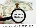 Small photo of Stochastic Oscillator.Magnifying glass showing the words.Background of banknotes and coins.basic concepts of finance.Business theme.Financial terms.