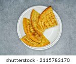 Small photo of Traditional indian food roghni naan in white plate top vie on grey background