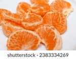 Small photo of peeled tangerine on a white background. tangerine segments to be consumed. tangerine details. details of natural foods of plant origin. tangerine with selective focus.