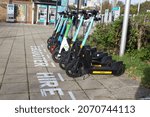 Small photo of London, England - November 7th 2021: a collection of E-scooters available to the general public, for hire outside Mudchute DLR station