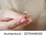 Caucasian woman holding simple solitaire diamond engagement ring white gold 