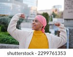 Small photo of Young woman in pink scarf fights cancer disease and feels strong to overcome it. Concept: disease, fight, health care