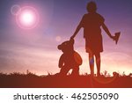 Silhouette girl holding per rocket and teddy bear at sunset. Concept big dream