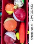 Small photo of Fishing lures and bobbers in a tackle box.