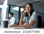 Small photo of We put quality over quantity. Portrait of a young woman using a headset and computer in a modern office.