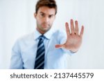 Small photo of Know your limits. Portrait of a businessman with a stern expression and holding up his hand in a stop motion.
