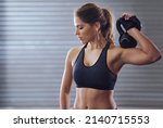 Small photo of Every body deserves to look its best. Shot of a young woman working out with kettlebells.