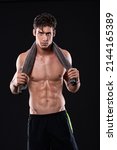 Small photo of ABsolute discipline. Studio shot of a muscular bare-chested young man isolated on black.