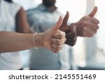 Small photo of Time to go all the way with our business. Cropped shot of an unrecognizable group of businesspeople standing together and making a thumbs-up gesture in the office.