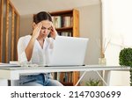 Small photo of This the worst day ever. Shot of a young businesswoman experiencing a headache while working from home.