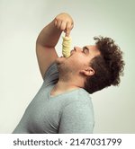 Small photo of For my next trick I will make these chips disappear. Studio shot of an overweight man shoving a stack of chips down his throat.