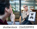 Small photo of Gaining access into the subconscious mind. Shot of a mature psychologist conducting an inkblot test with her patient during a therapeutic session.